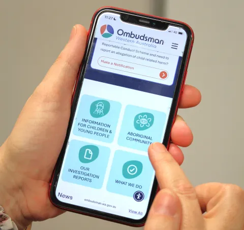 Hands holding mobile phone showing the website